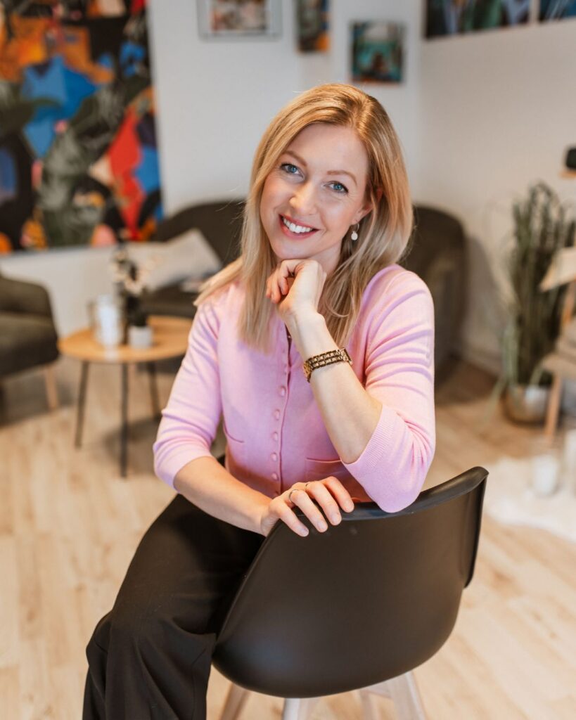 Kathi Walter sitzt lächelnd auf einem Stuhl.