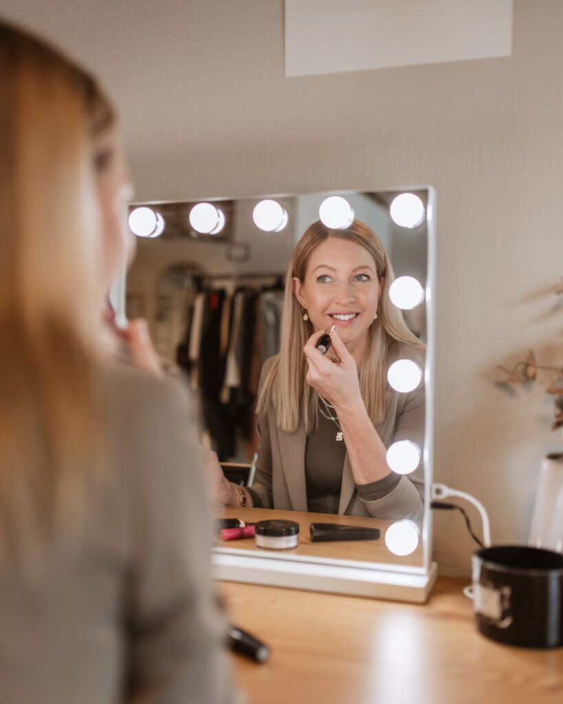 Kathi Walter schminkt sich vor einem Spiegel mit Licht.